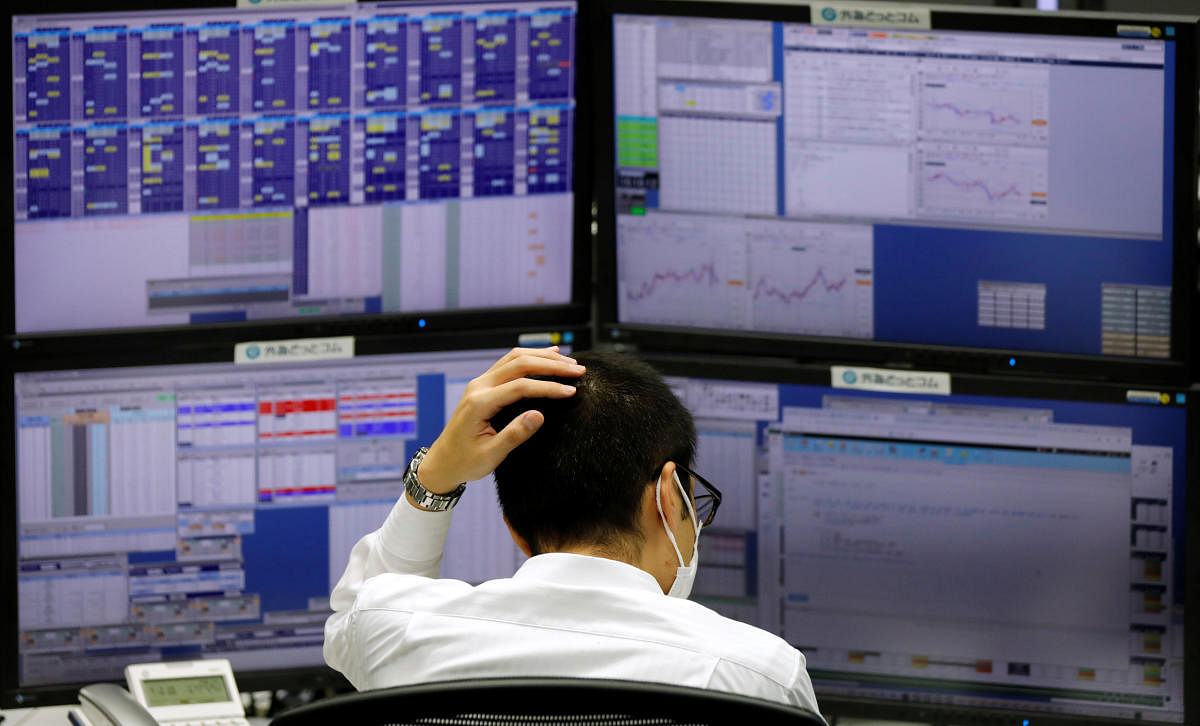 n employee of a foreign exchange trading company works in front of monitors in Tokyo. Reuters photo