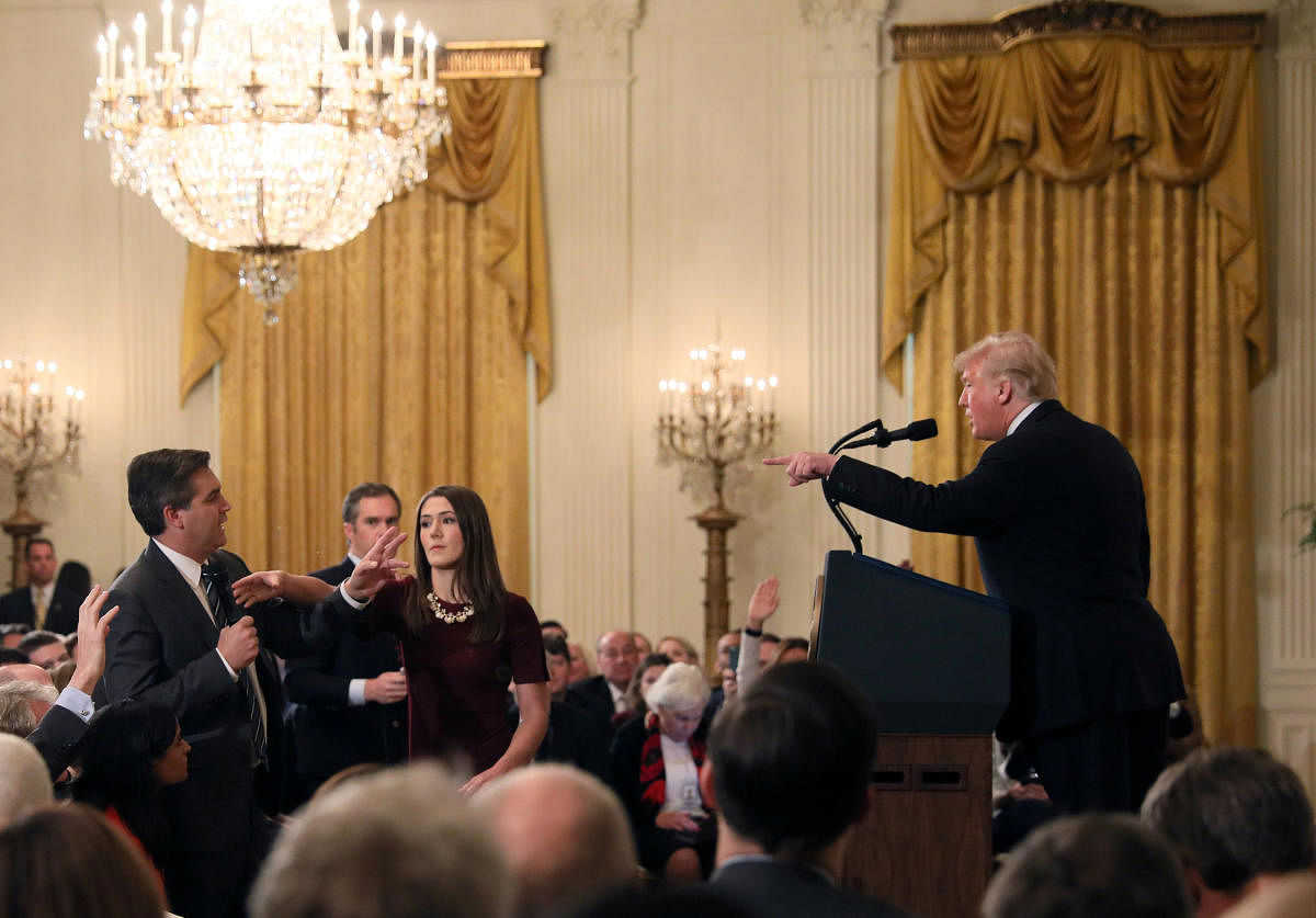 A White House staff member reaches for the microphone held by CNN's Jim Acosta as he questions U.S. President Donald Trump during a news conference in Washington. Reuters photo