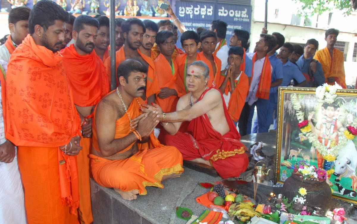 Priest Chandru offering Dattamala to Maheshkumar Kattinamane in Chikkamagaluru on Monday.