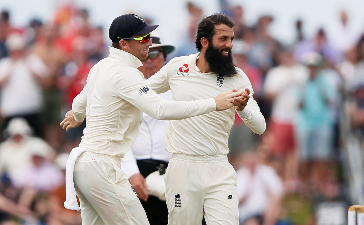  England's Moeen Ali (right) celebrates with team-mate Jos Buttler after desmissing Sri Lanka's Dimuth Karunaratne on the fourth day of the first Test in Galle on Friday. Reuters