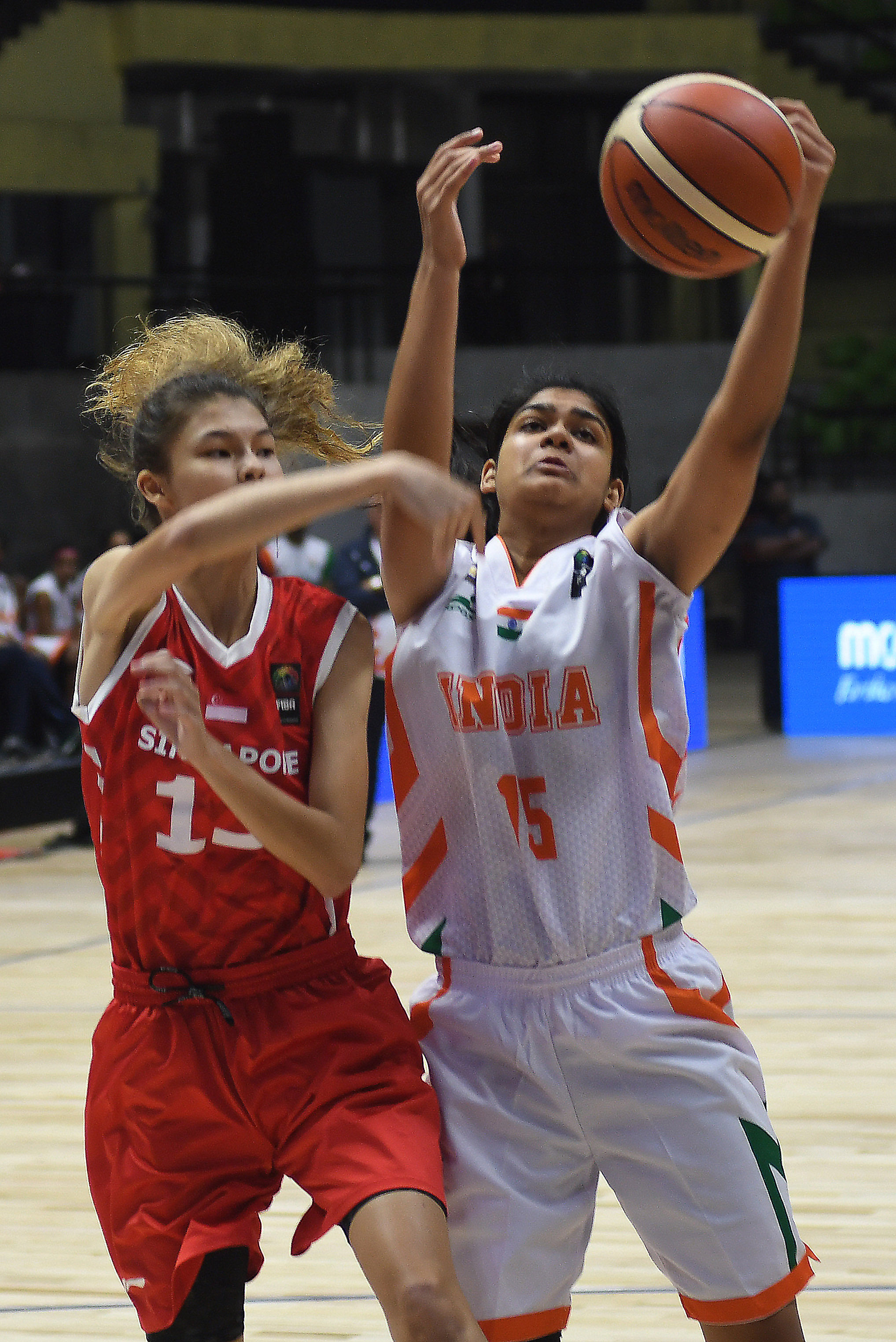 India's Sushanthika Chakravarty (right) and Mabel Wen Anton of Singapore vie for the ball during their Division B game on Tuesday. DH Photo/ Srikanta Sharma R