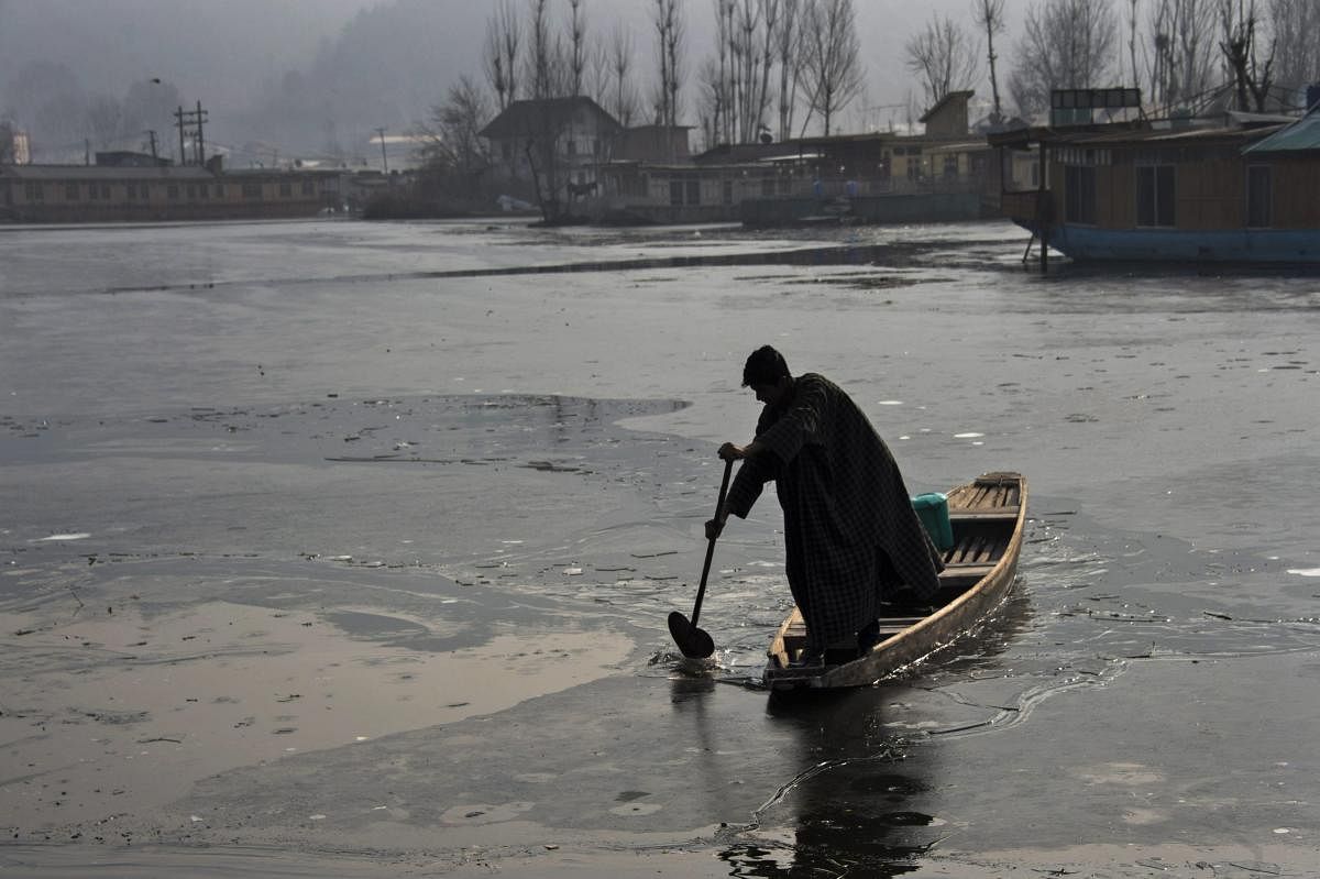 A man rows his boat on the partially frozen Dal Lake in Srinagar. PTI file photo