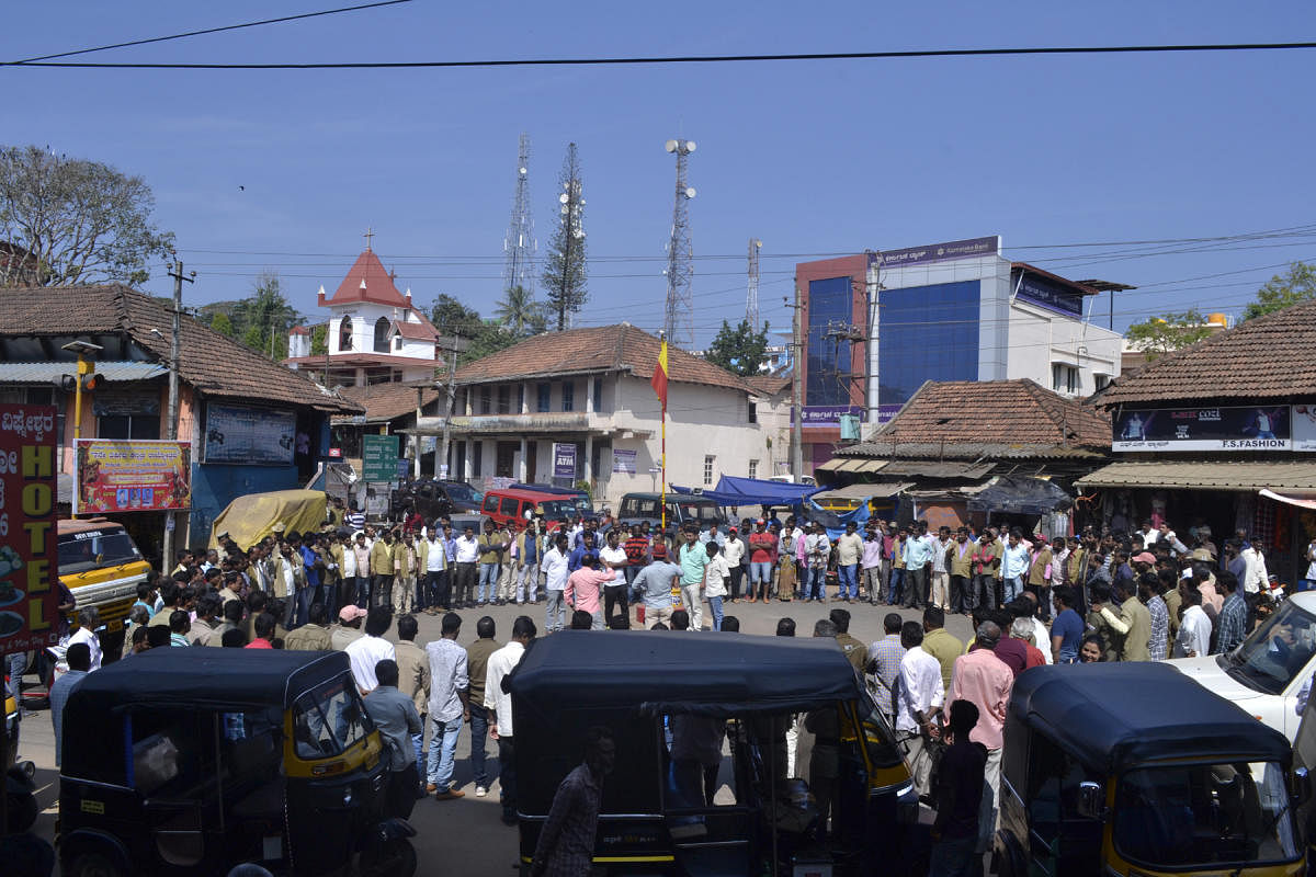 Members of Auto Drivers and Owners’ Union form a human chain at Kannada Circle in Suntikoppa on Sunday. 