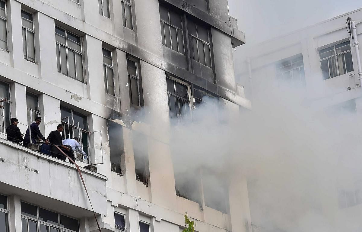 Smoke billows out of a window after a fire broke out on the fifth floor of a high-rise office building at Park Street, in Kolkata on Monday. PTI