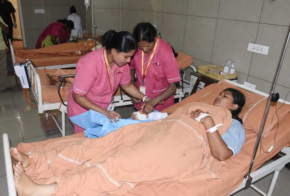 Staff nurses check right arm of a student who sustained injuries in road mishap that took place near NR Pura in Chikkamagaluru district on Saturday morning. DH Photo