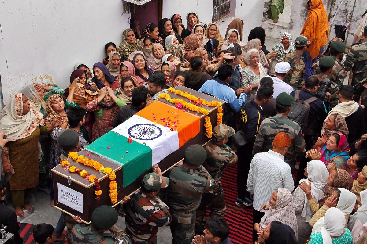 Army jawans carry the body of their colleague Varun Katal during his funeral at Village Mawa in Samba, about 55km from Jammu, on Sunday. Kattal was killed on Saturday in a sniper fire during a ceasefire violation by Pakistan along the Line of Control.
