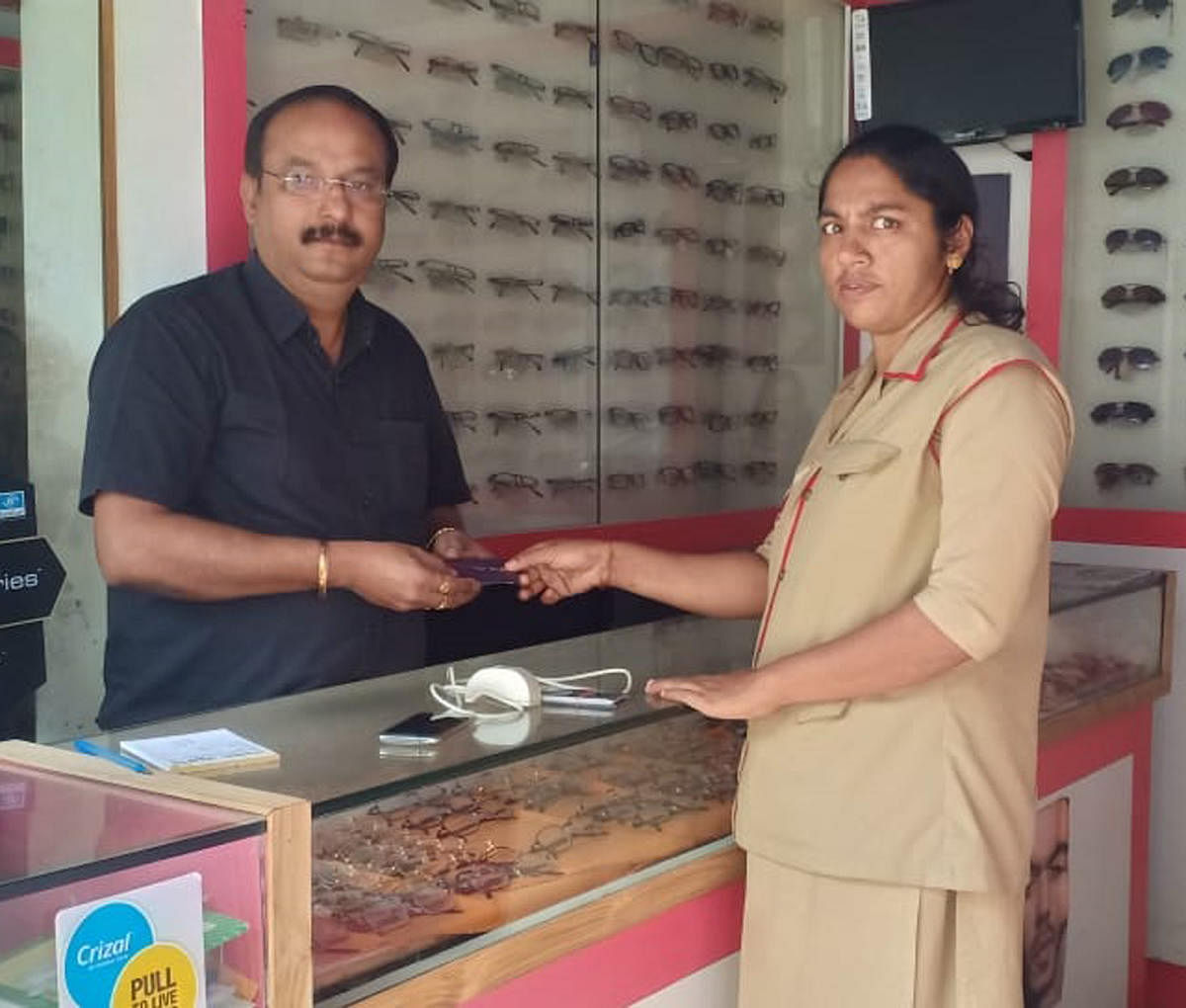 Postwoman Vinaya opens an IPPB account and hands over IPPB’s QR card to a shopkeeper in Chikkamagaluru.