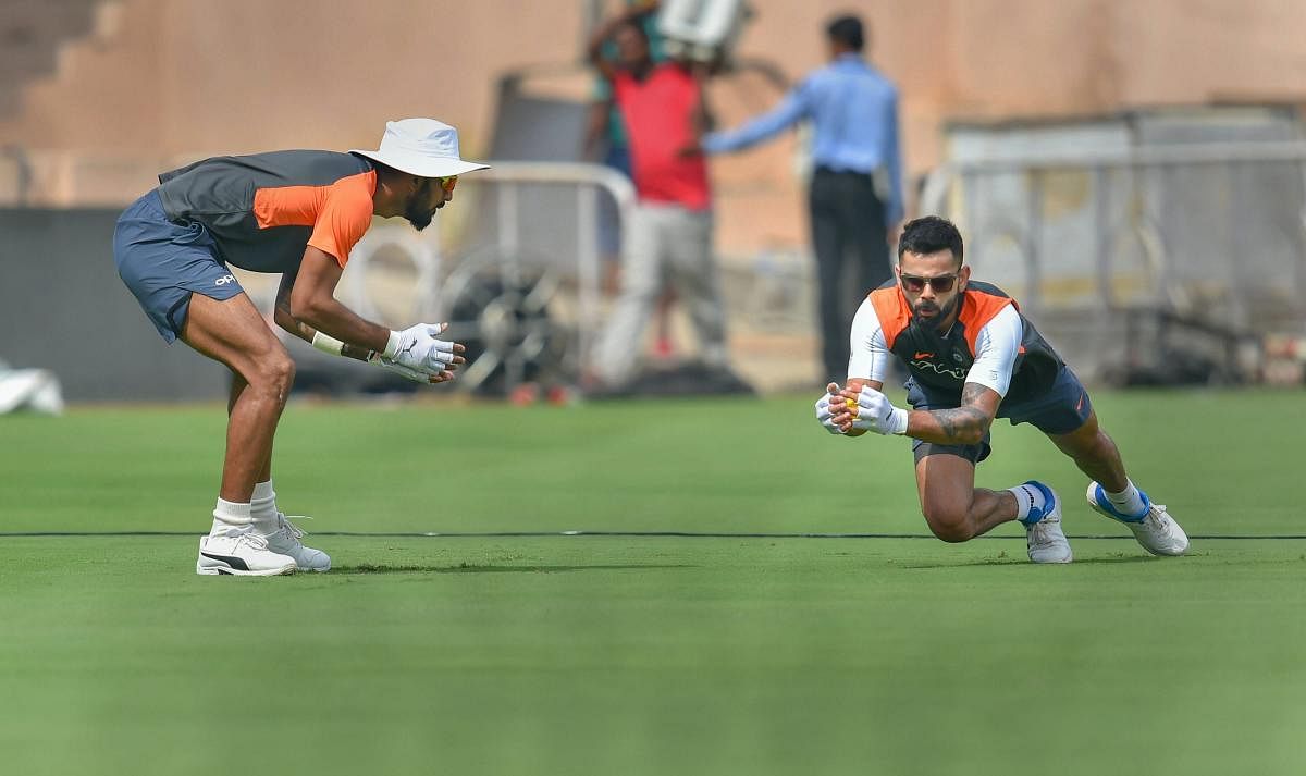 EFFORTLESS: Indian captain Virat Kohli (right) takes a catch during a practice session as KL Rahul looks on in Hyderabad on Thursday. PTI