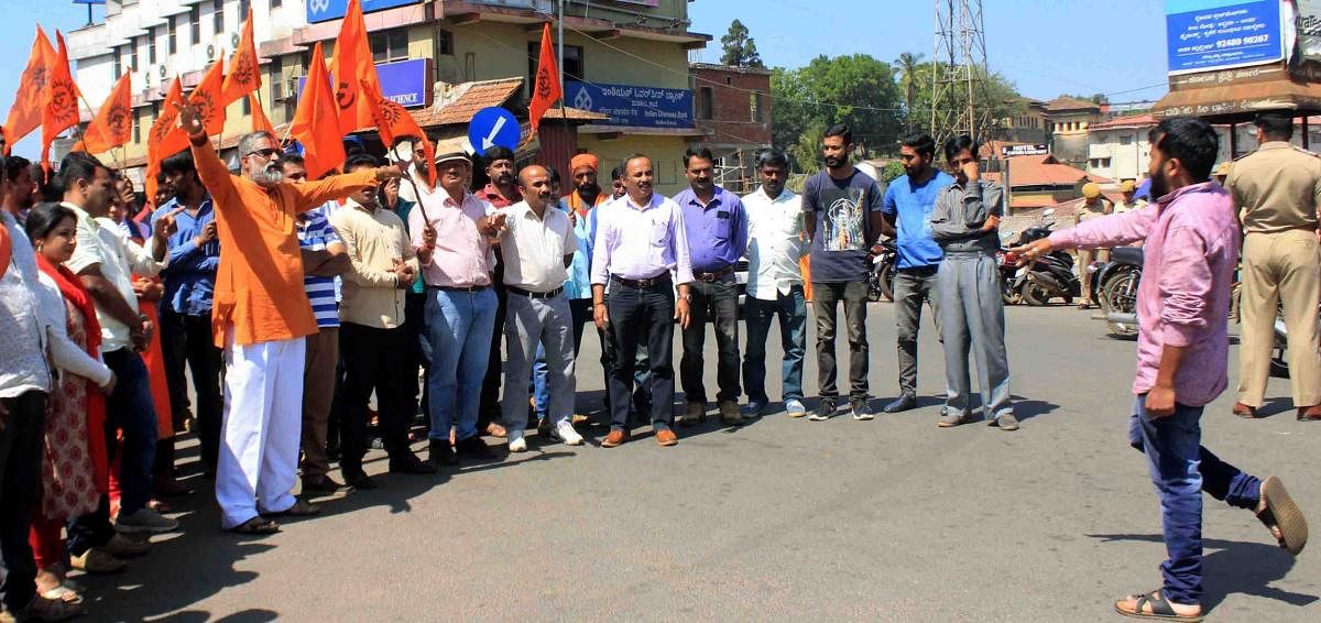 Members of BJP, VHP and Hindu Jagarana Vedike stage a protest against the arrest of journalist Santhosh Thammaiah, at General Thimmaiah Circle in Madikeri on Wednesday.