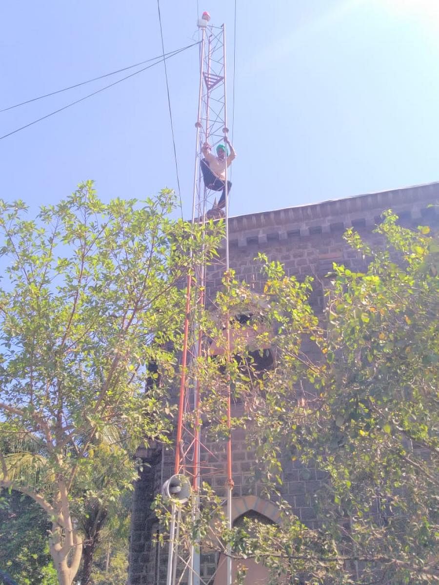 A protesting sugarcane Belagavi farmer climbs up a mobile tower to draw government's attention to farmers' plight on Friday. DH photo.