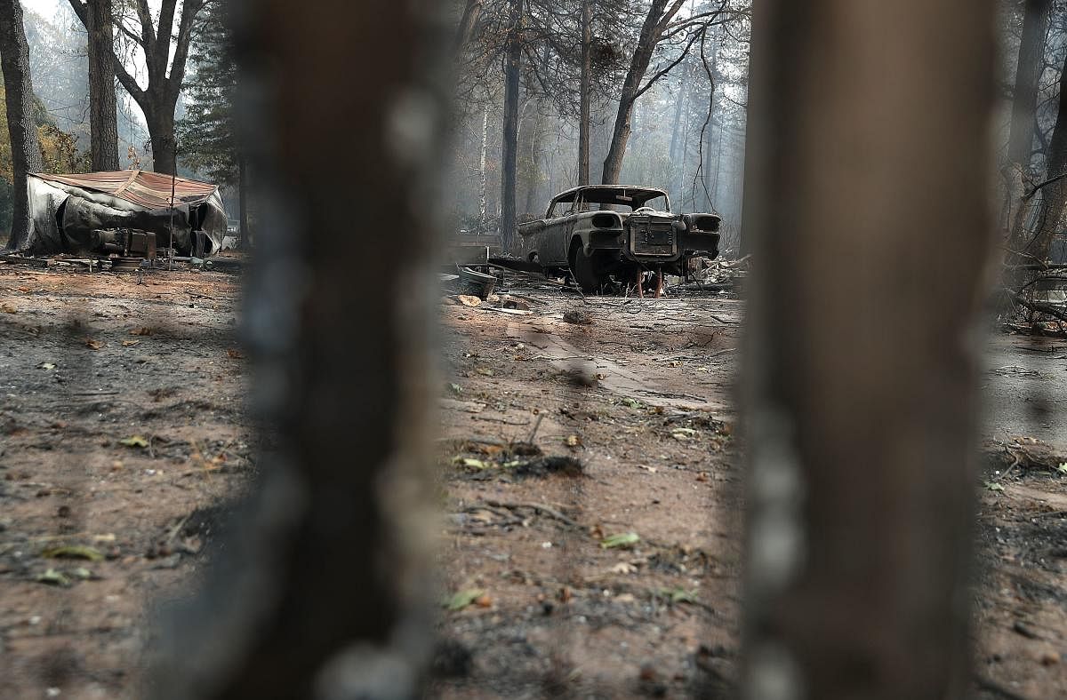 A burned out car sits next to a home destroyed by the Camp Fire on November 16, 2018 in Paradise, California. Reuters