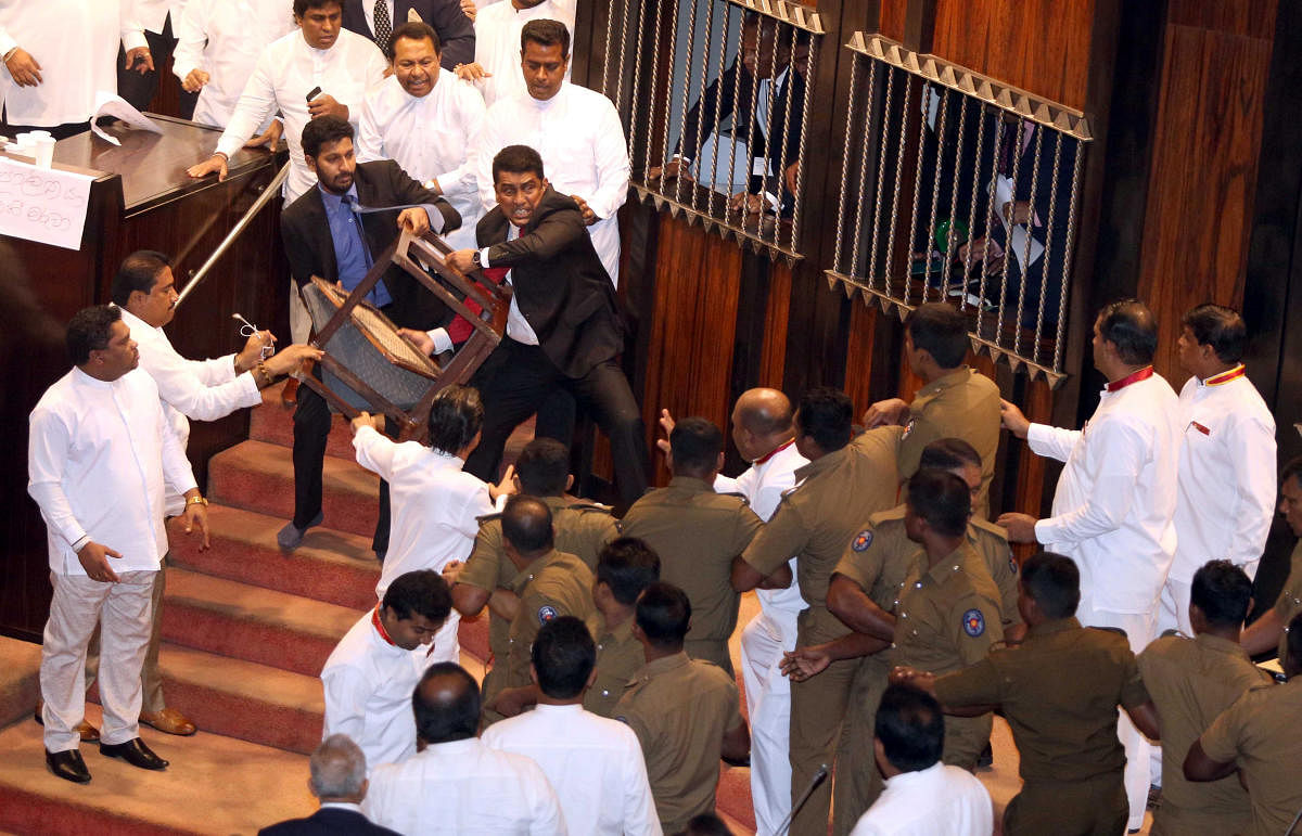 Parliament member Johnston Fernando who is backing newly appointed Prime Minister Mahinda Rajapaksa throws a chair at police who are there to protect parliament speaker Karu Jayasuriya (not pictured) during a parliament session in Colombo, Sri Lanka Novem