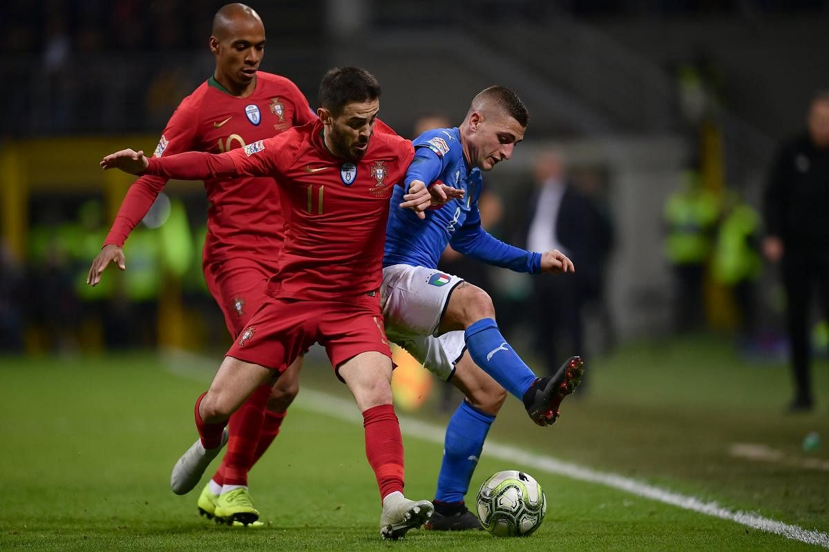 Italy's Marco Verratti (right) holds off Portugal's Bernardo Silva (centre) and Joao Mario during their match in Milan on Saturday. AFP