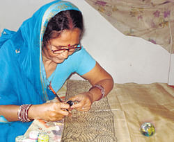 Veteran Madhubani artist Urmila Devi paints on a saree.