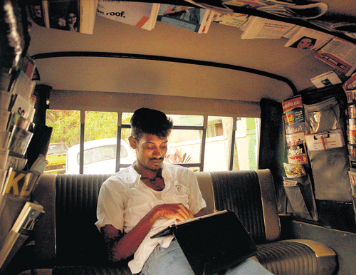 A traveller browses his gadget using wifi facility in auto rickshaw.