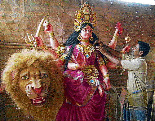 Artisans give final touches to idols of Durga.