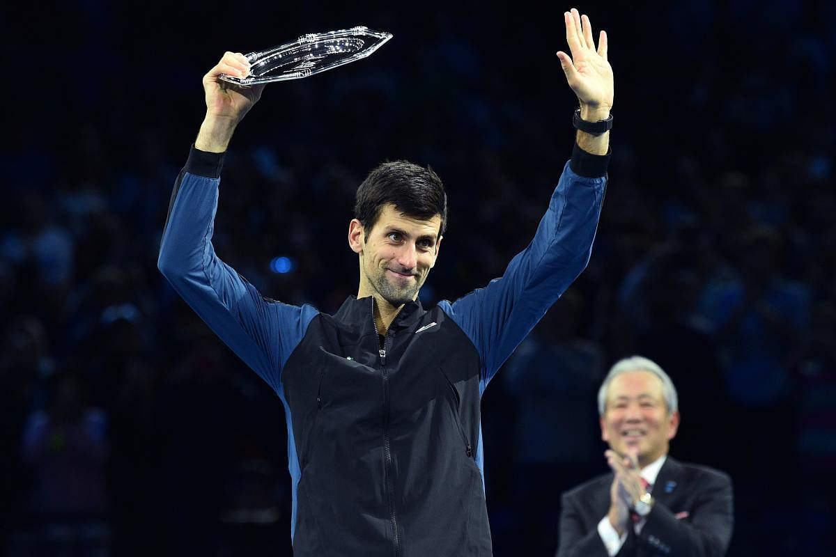 Serbia's Novak Djokovic waves to the crowd holding his runners-up trophy after losing to Germany's Alexander Zverev in the title cash of the ATP Finals. AFP