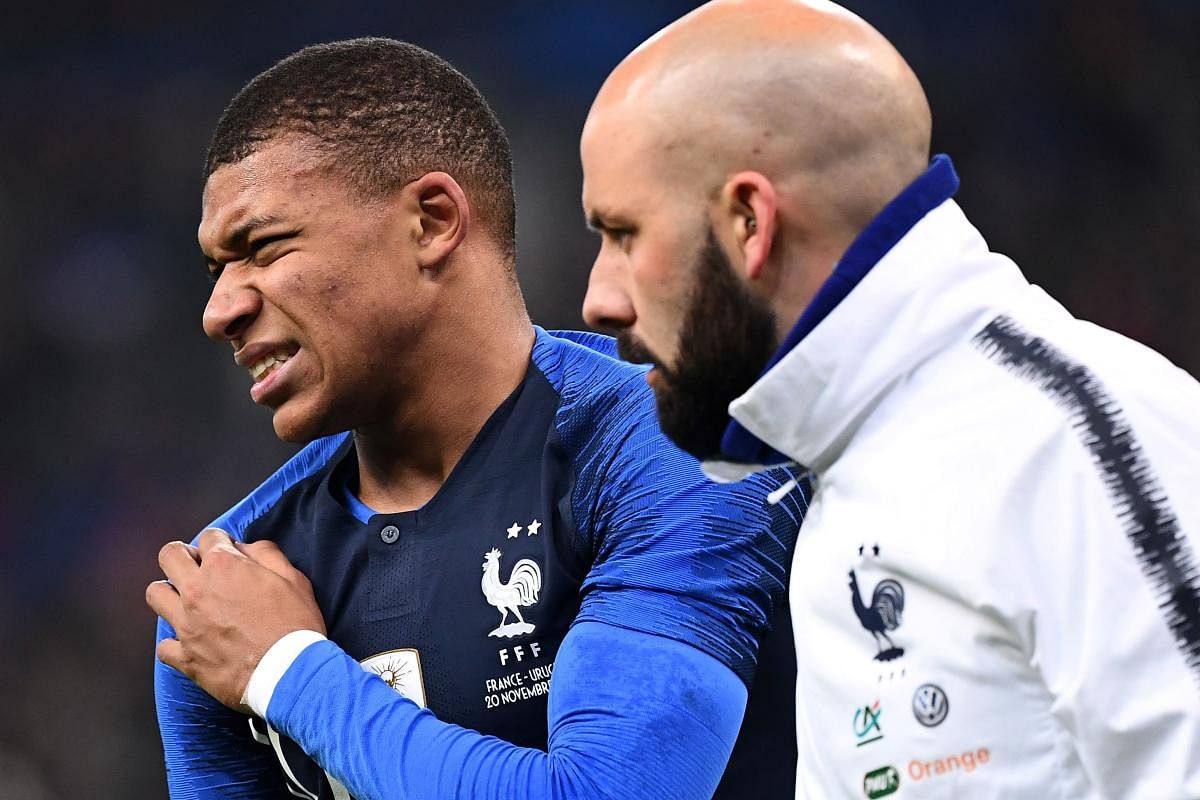 France's midfielder Kylian Mbappe (left) leaves the pitch after getting injured during a friendly against Uruguay on Tuesday. AFP
