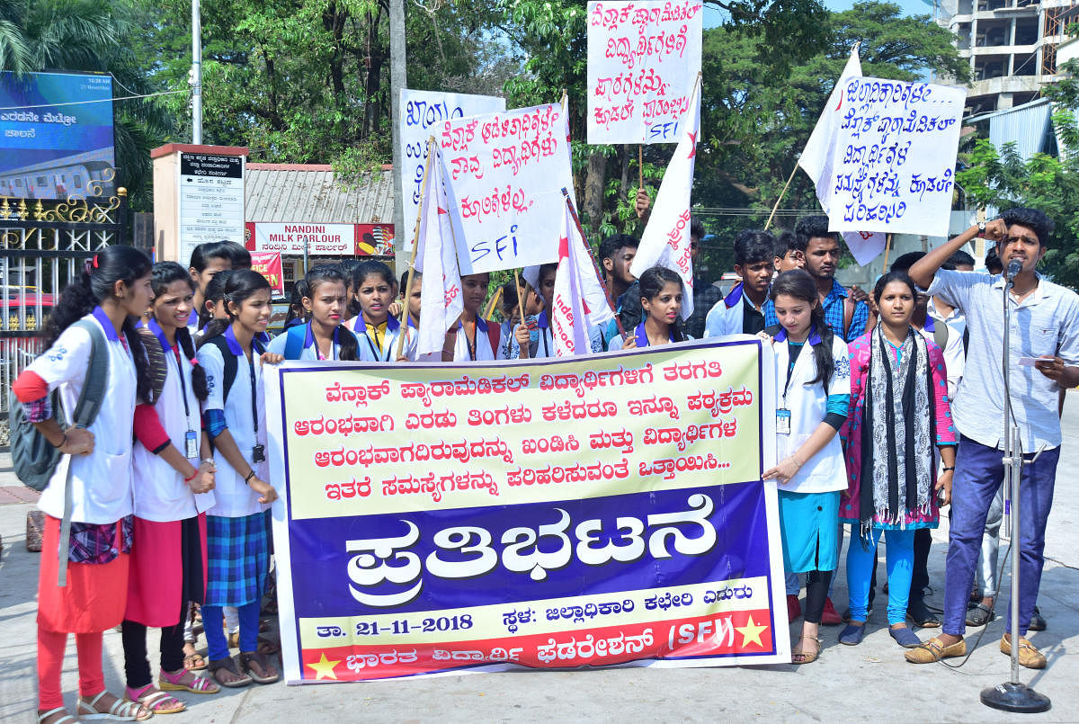 Students of paramedical courses at the district government Wenlock Hospital stage a protest in front of the deputy commissioner’s office in Mangaluru on Wednesday.