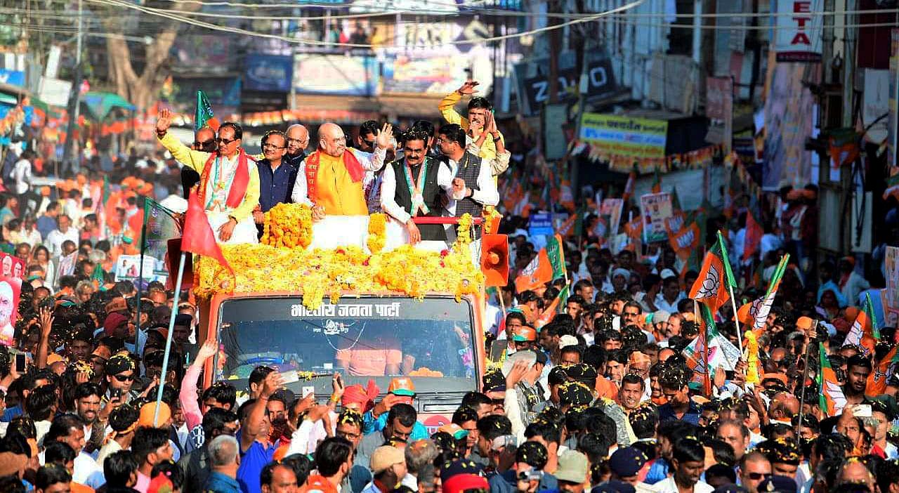 BJP National President Amit Shah with Madhya Pradesh Chief Minister Shivraj Singh Chouhan and BJP State President Rakesh Singh during a roadshow in Guna, on October 9, 2018. (PTI File Photo)