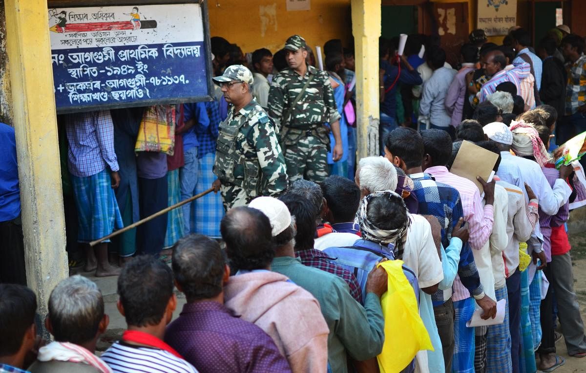 People stand in line to check their names on the first draft of the National Register of Citizens (NRC) at Gumi village of Kamrup district in the Indian state of Assam on January 1, 2018. Around 13 million people in northeastern India's Assam woke up to u