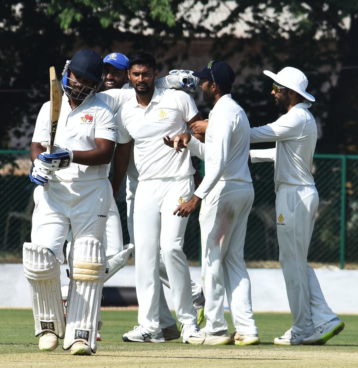 Karnataka paceman Ronit More (centre) is congratulated by team-mates after dismissing a Mumbai batsman in the Ranji Trophy game at Belagavi on Thursday. DH PHOTO/ Tajuddin Azad