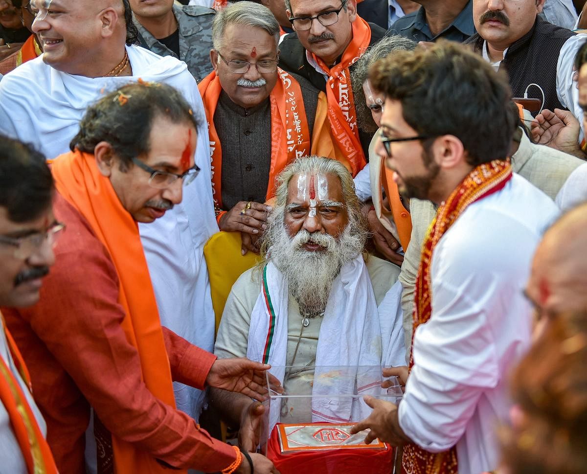 Shiv Sena chief Uddhav Thackeray and Yuva Sena chief Aditya Thackeray present a silver brick to Ram Janmabhoomi Nyas chief, Mahant Nritya Gopal Das, at Laxman Qila ahead of the Ram Temple event to be held tomorrow, in Ayodhya, Saturday, Nov.24, 2018. (PTI