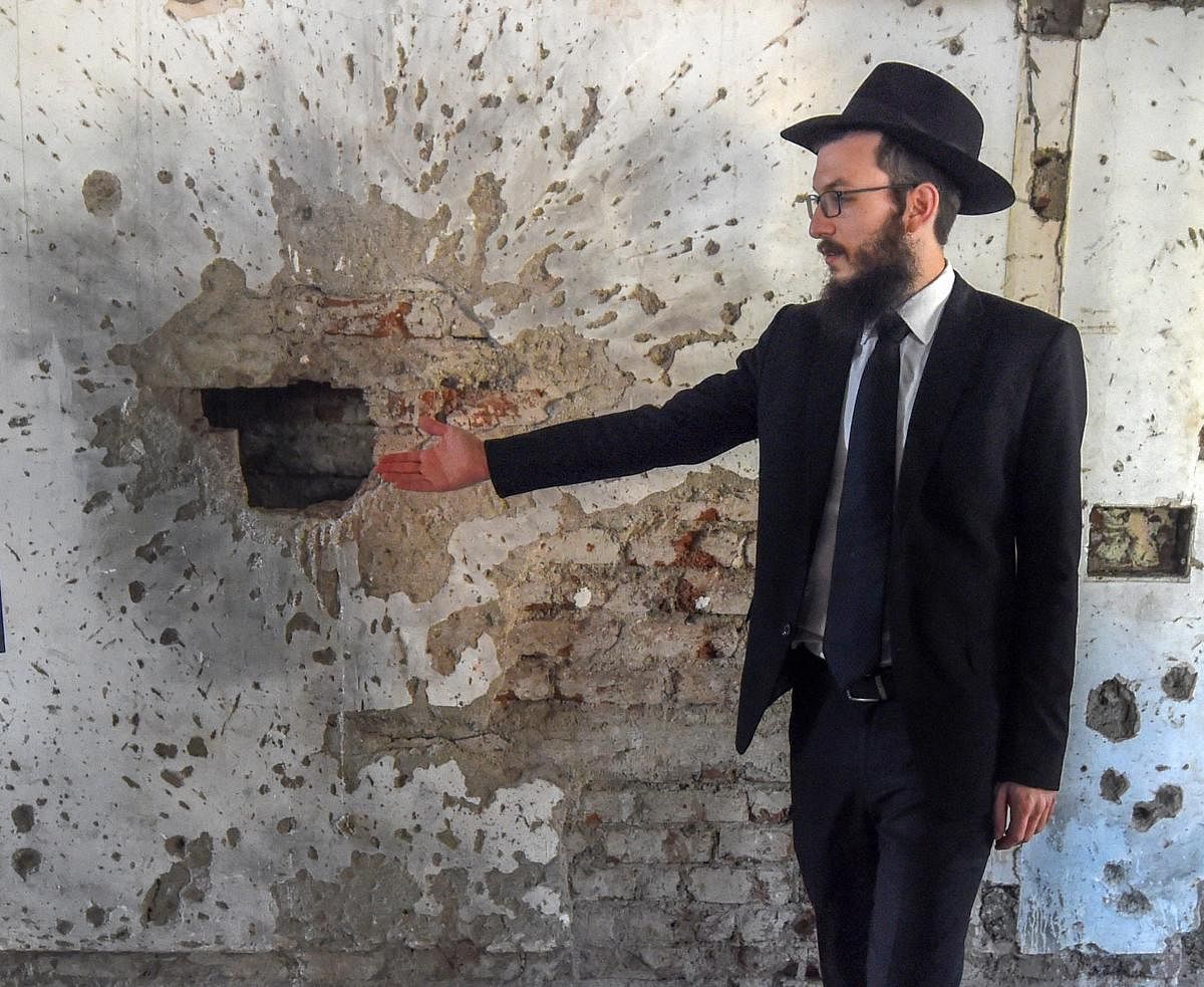 TRACES OF TERROR: Rabbi Israel Kozlovsky gestures at the bullet marks in Nariman House from the 26/11 attacks, in Mumbai on Sunday. PTI