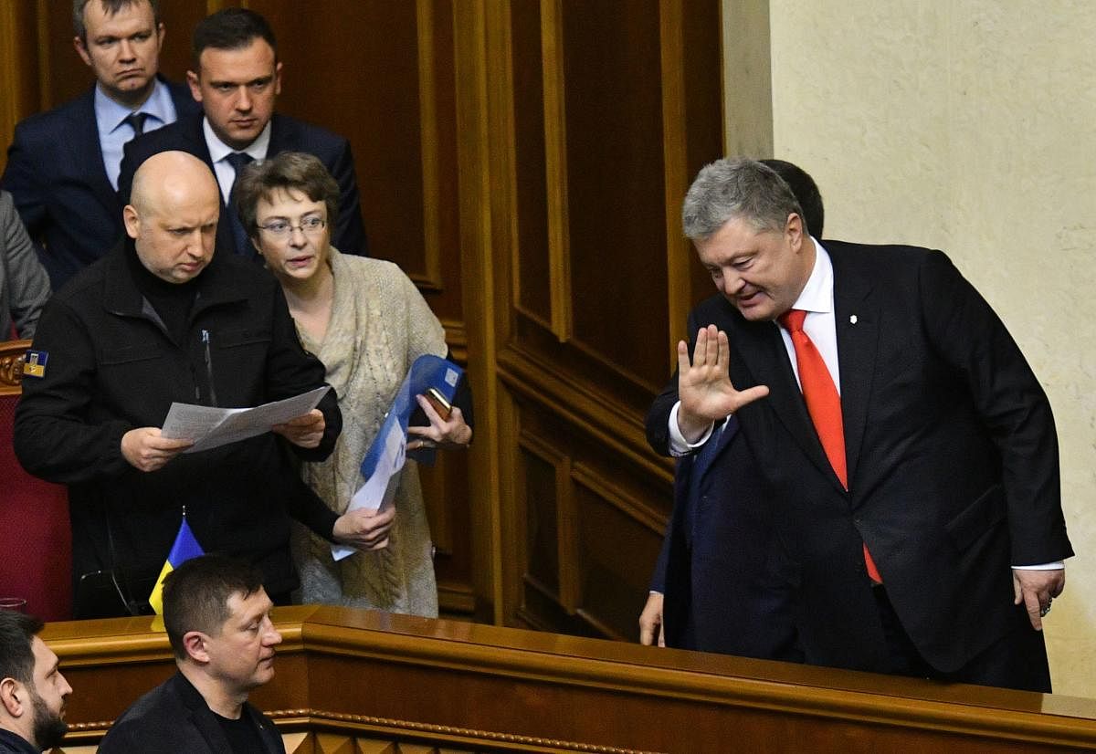 Secretary of the National Security and Defence Council of Ukraine Oleksandr Turchynov (left) watches as Ukrainian President Petro Poroshenko (right) waves to Ukrainian MPs after they voted on the request of the Ukrainian President to impose martial law in