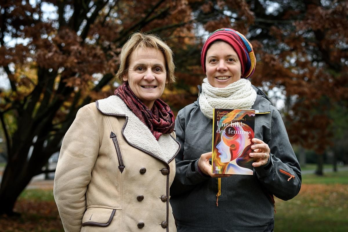 Geneva theology professors Elisabeth Parmentier and Lauriane Savoy pose with an edition of "A Women's Bible" on November 20, 2018 in Geneva. AFP