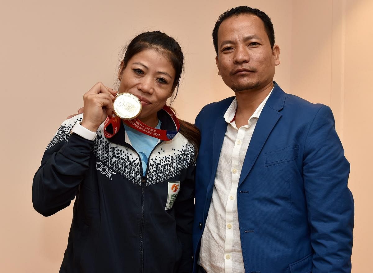Boxer Mary Kom and her Husband K Onler Kom poses with gold medal after winning the final match of women's light flyweight 45-48 kg against Ukraine's Hanna Okhota at AIBA Women's World Boxing Championships, in New Delhi. PTI Photo