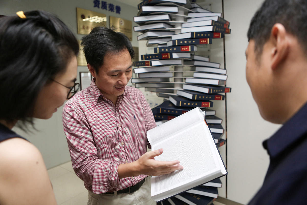 Scientist He Jiankui shows "The Human Genome", a book he edited, at his company Direct Genomics in Shenzhen, Guangdong province, China August 4, 2016. Picture taken August 4, 2016. REUTERS/Stringer ATTENTION EDITORS - THIS IMAGE WAS PROVIDED BY A THIRD PA