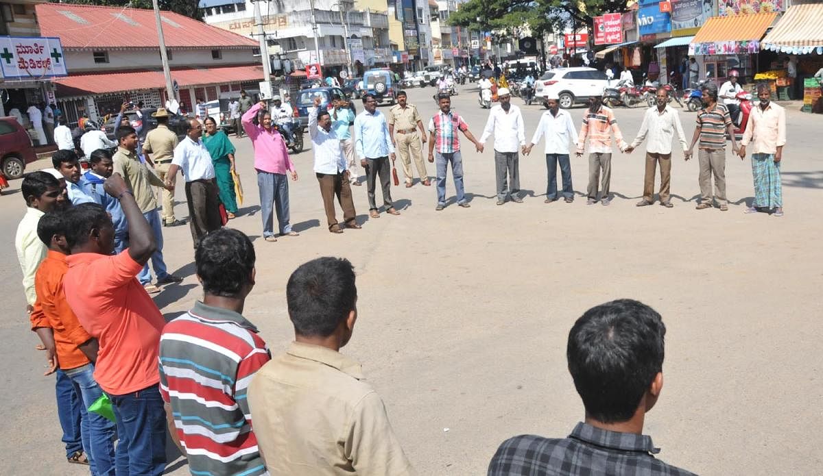 Members of Bhoomi Matthu Vasati Vanchitara Horata Samiti conduct a protest at Azad Park Circle in Chikkamagaluru on Wednesday.