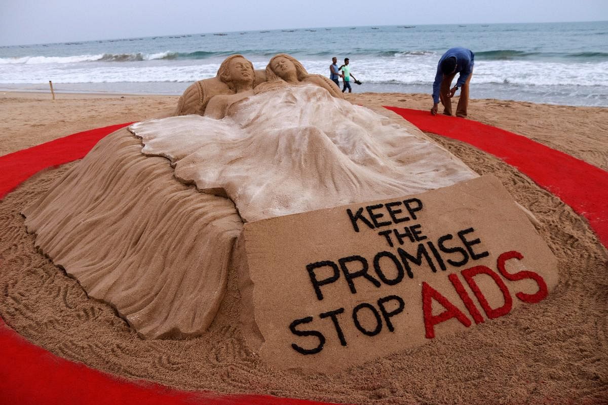 Sand sculptor Sudarsan Pattnaik creates a sand art to spread awareness and extend solidarity towards people living with AIDS, on the eve of World AIDS Day in Puri. PTI photo