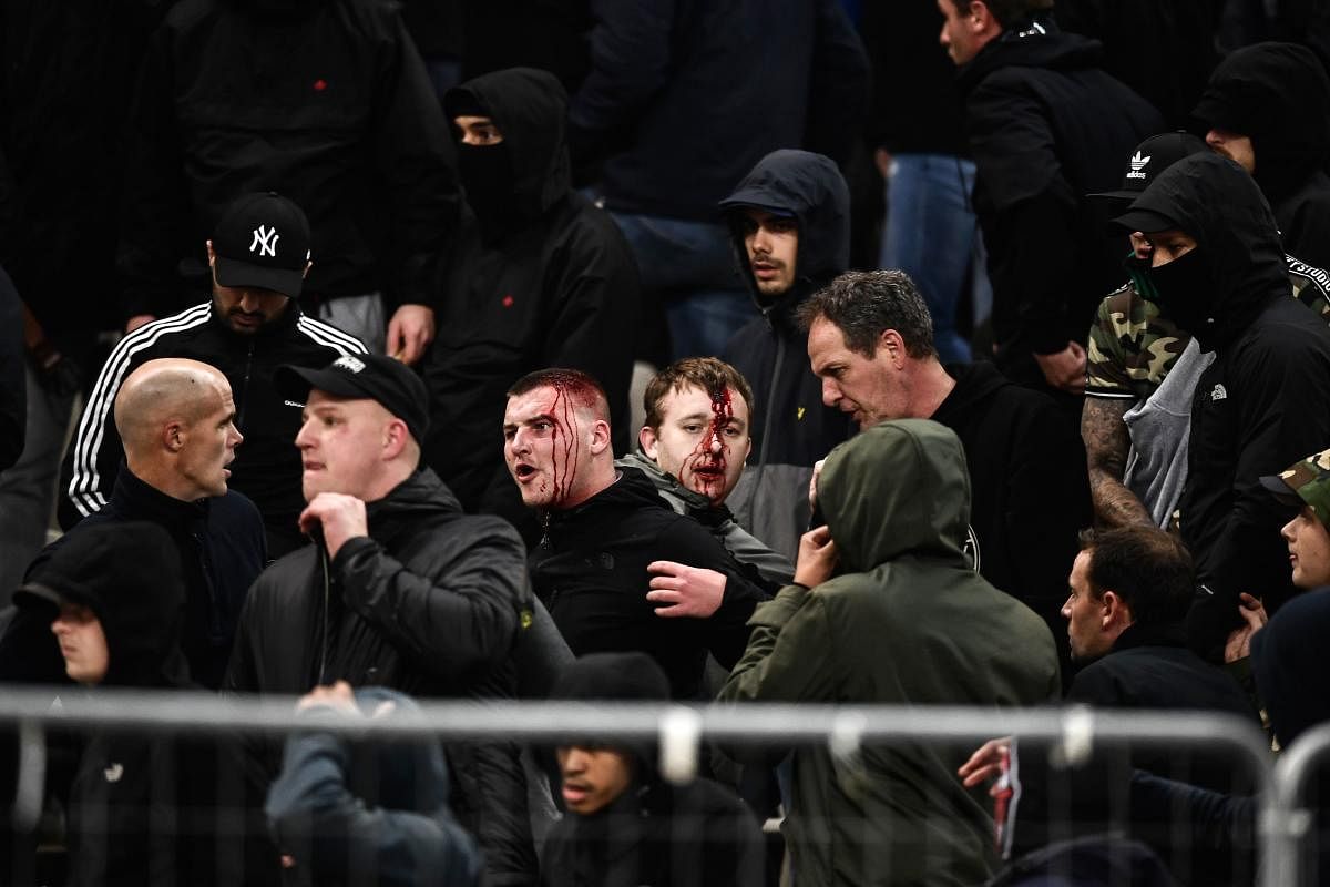 UNFORTUNATE Bleeding Ajax fans react after clashes with Greek riot police prior to the start of the Champions League match between AEK Athens and Ajax on Tuesday. AFP
