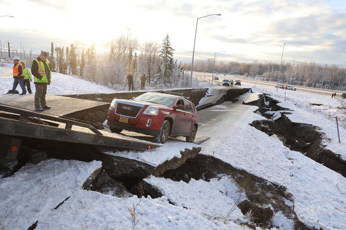 A stranded vehicle is pulled out of a collapsed section of roadway near the airport after an earthquake in Anchorage, Alaska. Reuters Photo