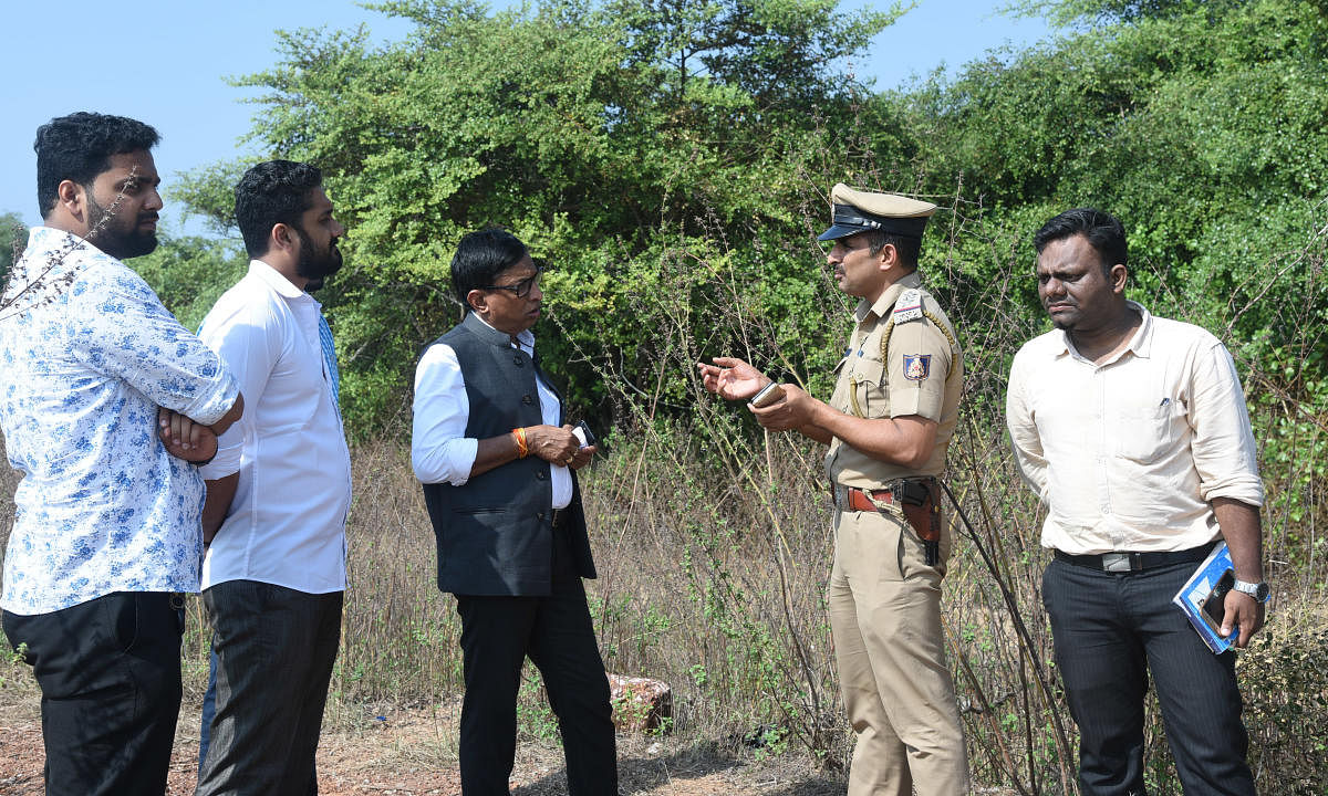 MLC S L Bhoje Gowda listens to a point explained by a police inspector at Alive Bagilu Beach near Thota Bengre on Saturday evening.