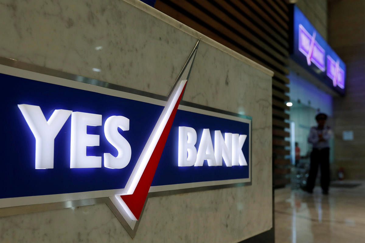 FILE PHOTO: A security guard stands outside a Yes Bank branch at its headquarters in Mumbai. REUTERS
