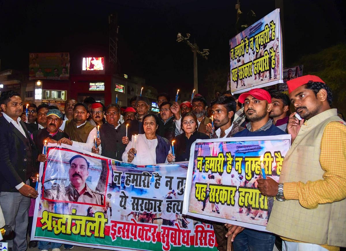 Samajwadi Party workers take part in a candlelight march to pay tribute to police inspector Subodh Singh, who was killed in Monday's mob violence in Bulandshahr, in Allahabad, on Tuesday. PTI