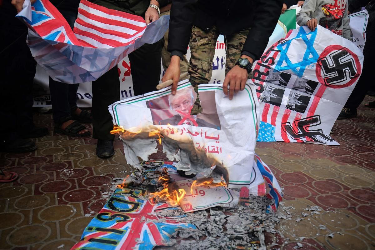 Palestinians burn makeshift flags during a demonstration against an upcoming UN General Assembly vote on a US-drafted resolution condemning the Palestinian Hamas movement in the town of Rafah in the southern Gaza Strip. AFP