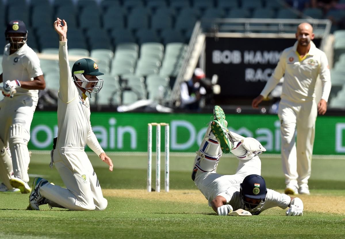 Cheteshwar Pujara (C) survives a run-out attempt as Australia's Peter Handscomb (2nd L) looks on during day one of the first cricket Test match at the Adelaide Oval on December 6. AFP