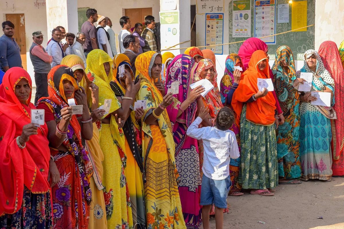 Voters show their identity cards as they wait in queues at a polling station to cast their votes for state Assembly elections, in Jaipur, Friday, Dec. 7, 2018. (PTI Photo)