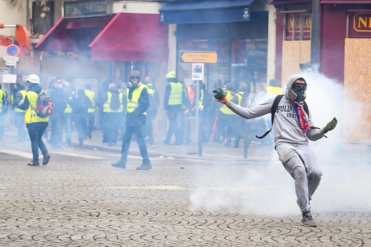 Protestors clash with police forces on December 8, 2018 in Paris, during a protest of "yellow vests" (gilets jaunes) against rising costs of living they blame on high taxes. - Paris was on high alert on December 8 with major security measures in place ahe