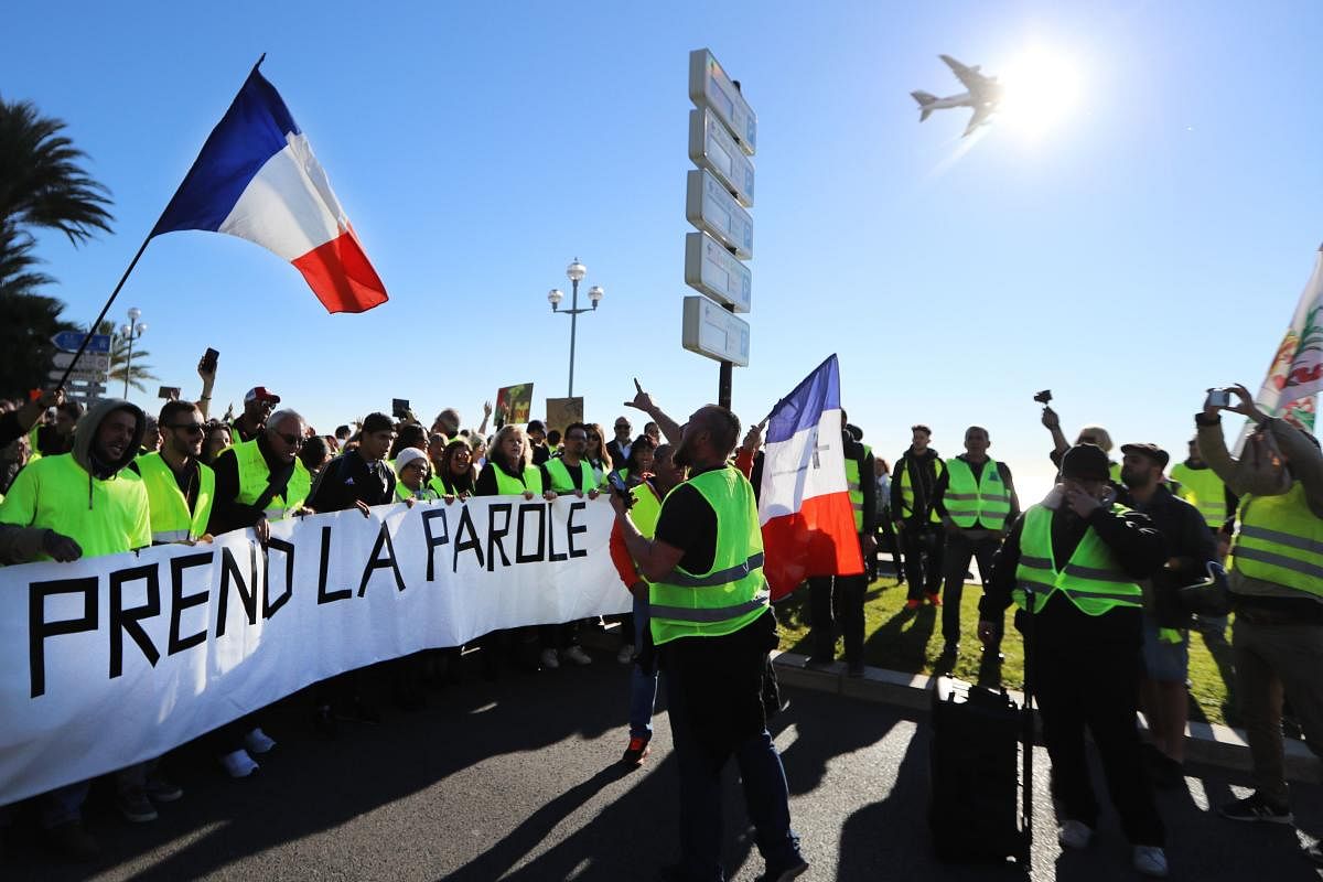 Protestors hold a banner reading "The People speaks out" on the "Promenade des Anglais" during a protest of Yellow vests (Gilets jaunes) against rising oil prices and living costs, in Nice, southeastern France. AFP file photo.