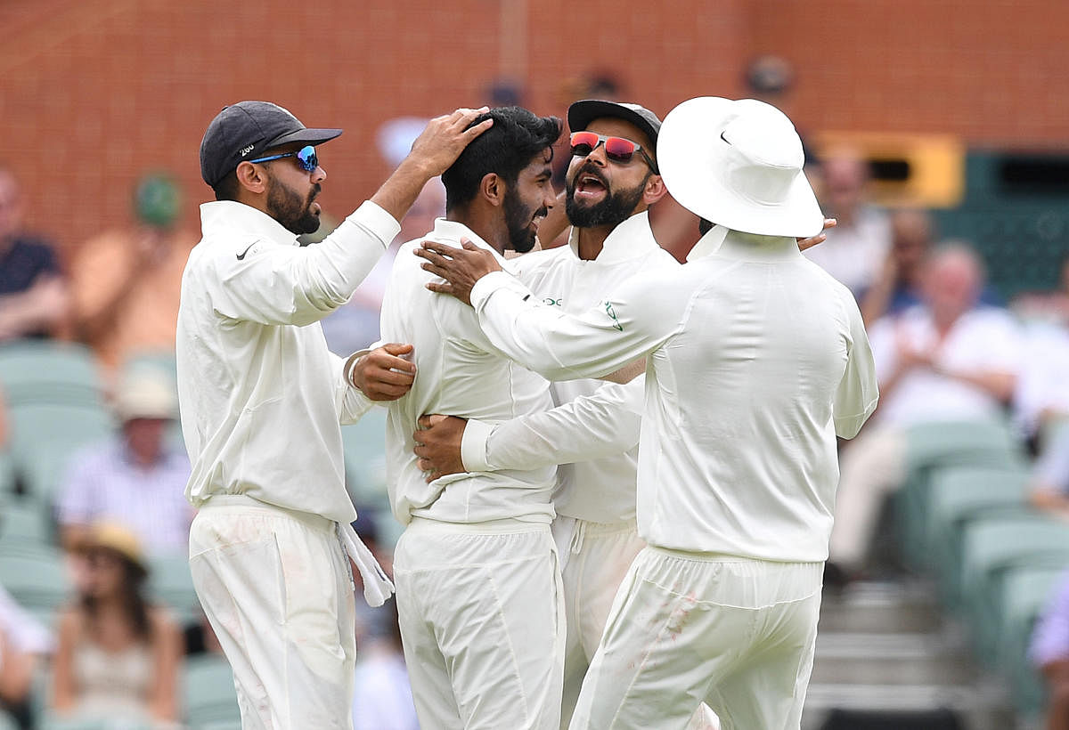 India's captain Virat Kohli (2nd R) celebrates with his teammate Jasprit Bumrah (2nd L) after Bumrah dismissed Australian batsman Peter Handscomb for 34 runs on day two of the first test match between Australia and India at the Adelaide Oval in Adelaide,