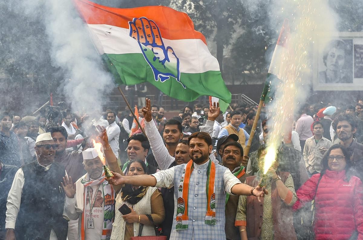 Congress party workers burst firecrackers as they celebrate the counting trends for the recent Assembly elections, at AICC headquarters in New Delhi. PTI