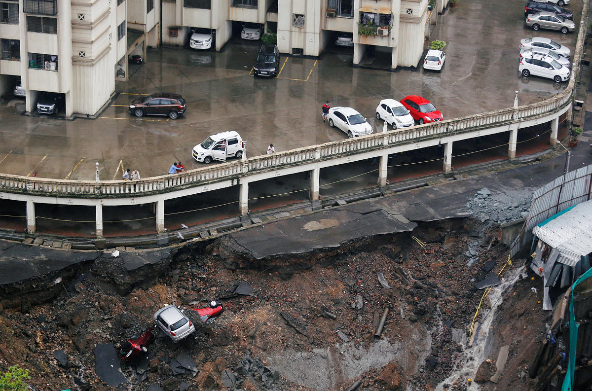 Cars are seen amidst debris after the wall of a residential building collapsed due to heavy rains in Mumbai. REUTERS