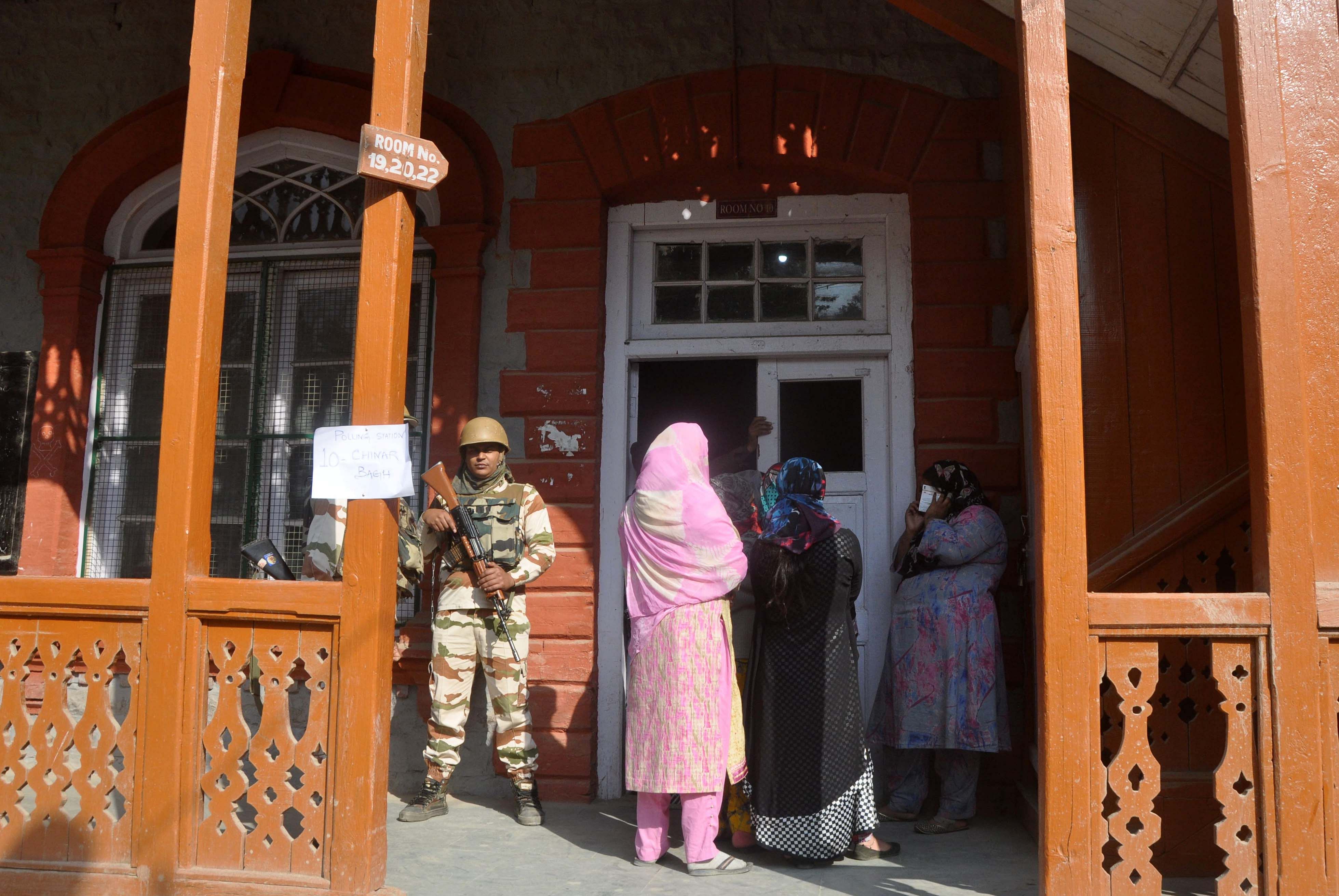 Women stand in a queue outside a polling station in Nowhatta in downtown Srinagar during the third phase of urban local body election on Saturday. (DH Photo/Umer Asif) 