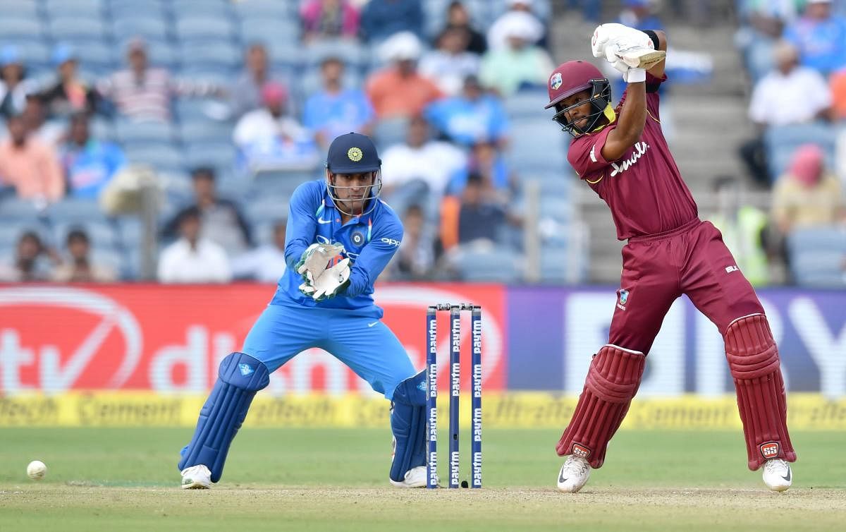 West Indies cricketer Shai Hope (R) plays a shot as India wicketkeeper Mahendra Singh Dhoni watch during the third one day international (ODI) cricket match between India and West Indies at the Maharashtra Cricket Association Stadium in Pune. AFP photo