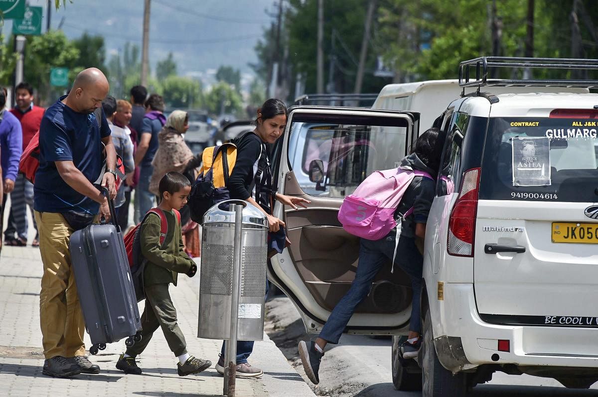 A tourist family boards a taxi at Boulevard Road in Srinagar on Tuesday. Tourism department and stakeholders have expressed apprehensions that the death of a tourist from Tamil Nadu in recent clashes, could negatively impact the arrival of visitors to Kas